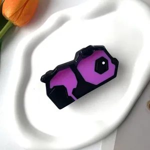 Gros plan sur la pince à cheveux panda géométrique noir et violet sur plateau