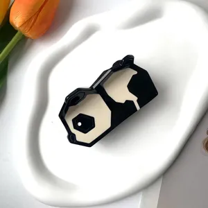 Détail d'une pince à cheveux en acétate motif panda noir et blanc sur plateau ondulé