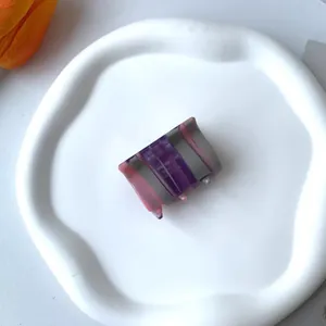 Detail of a purple and pink striped acetate hair claw with France Handmade inscription