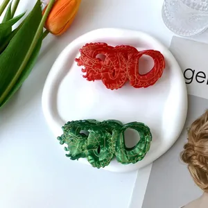 Elegant Chinese dragon hair claws in red and green acetate with gold detailing