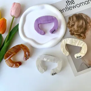 Minimalist marble pattern acetate hair claws in purple, amber, cream, and grey colors