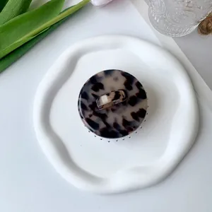 Detailed top view of a round acetate hair claw clip with a classic tortoiseshell pattern