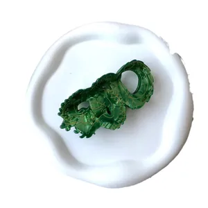 Elegant emerald green dragon-shaped hair claw clip with golden scale details