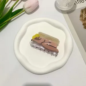 Artistic acetate hair claw clip shaped as a woman figure on a ceramic tray with tulips