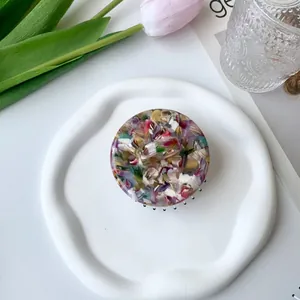 Overhead view of a colorful marble pattern acetate hair claw clip on a white ceramic tray