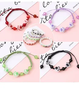 Dettaglio macro di braccialetti con zampa di gatto e anelli di perline in vari colori
