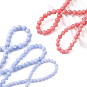 Polished synthetic stone round beads in light blue and pink orange with marble texture