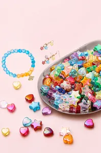 Macro view of iridescent acrylic heart and star beads for DIY handmade jewelry crafting