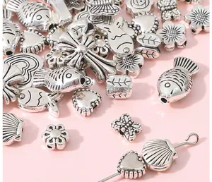 Macro detail of antique silver alloy charms including heart and flower for DIY jewelry