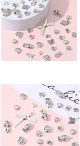 Detailed macro of vintage silver alloy charms featuring heart, flower, and butterfly shapes