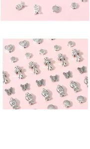 Detailed macro view of vintage silver alloy charms featuring hearts, roses and butterflies