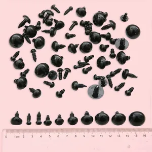 Varios tamaños de ojos de seguridad negros para muñecos DIY sobre fondo rosa suave
