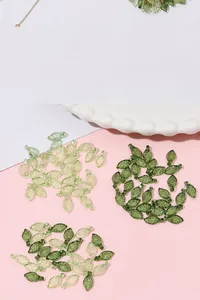 Detailed view of acrylic leaf-shaped beads with vein texture and top hanging holes