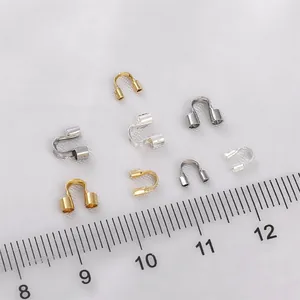 Dettaglio macro di proteggi-filo a U placcati in oro 14K con righello per la dimensione