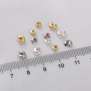 Close-up of 3mm-5mm 14K gold-filled crimp bead covers with ruler for size reference