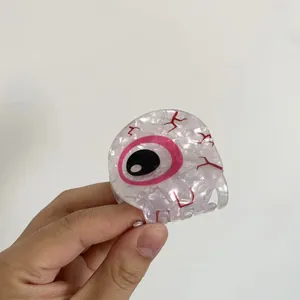 Dettaglio molletta a occhio in marmo bianco con iride rosa e vene rosse per Halloween