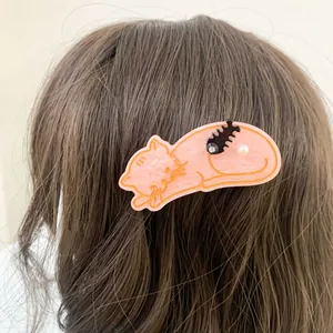 Rosa Katzen-Acryl-Haarspange mit Fischgräte und Perle auf braunem Haar getragen