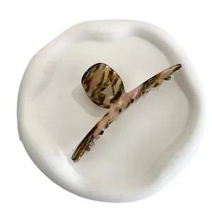 Minimalist marble pattern acetate hair claw clip displayed on a white decorative tray