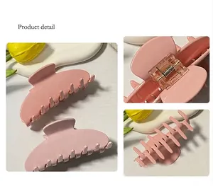 Detalle de pinza para el pelo rosa mate con resorte metálico y dientes suaves
