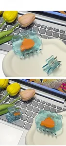 Detailed view of light blue acrylic hair claws with vibrant orange goldfish design