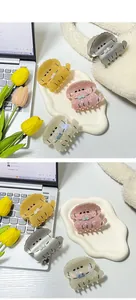 Detalle de cuatro pinzas para el pelo de acetato con forma de perro y acabado perlado