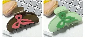Detail view showing bow hair claws in brown pink and mint green matte resin finish