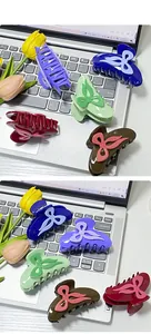 Close-up of colorful bow hair claws in purple, navy, and green on a desk background