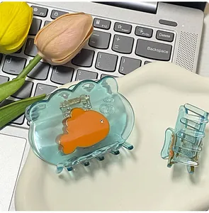 Detail of blue fish hair claws on a wavy tray with tulip accents and a laptop