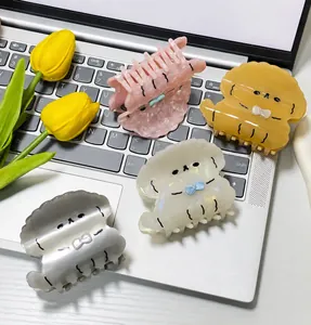 Detail of dog-shaped acetate hair claws in multiple colors on a laptop keyboard