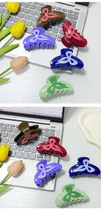 Detail view of five assorted colorful acetate bow hair claws on a desk background