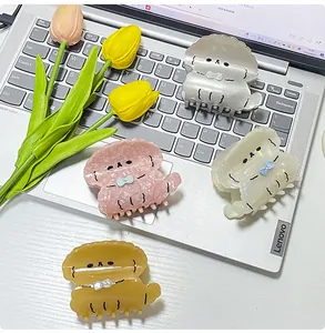 Detalle de cuatro pinzas para el cabello de acetato con forma de perro sobre un teclado