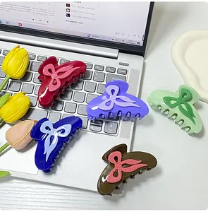 Set of five colorful bow-knot hair claw clips shown on a silver laptop background