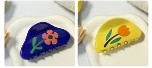 Dettaglio delle mollette per capelli con motivi a tulipano rosa e arancione in acrilico