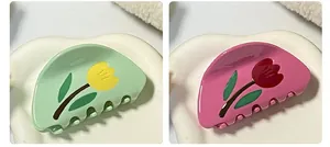 Dettaglio ravvicinato delle mollette per capelli a tulipano in verde menta e rosa lucido