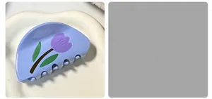 Dettaglio della pinza per capelli azzurra con tulipani viola su vassoio bianco