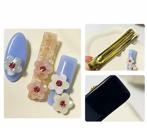 Dettaglio di fermagli per capelli in acetato con fiori glitterati e strass rosa