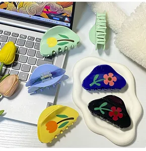Dettaglio di fermagli per capelli con motivo a tulipani in vari colori, verde e blu