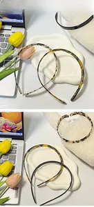 Detail view of thin non-slip acetate headbands in tortoiseshell and black with teeth