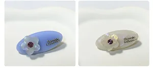Dettaglio di fermagli per capelli a fiore in acetato in bianco perla e azzurro