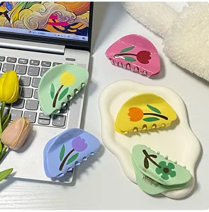 Dettaglio delle pinze per capelli a forma di tulipano su vassoio a nuvola bianca