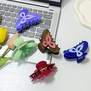 Set of five colorful butterfly bow hair claws displayed on a silver laptop with flowers