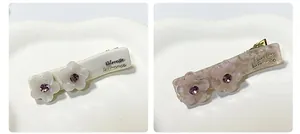 Dettaglio di fermagli per capelli in acetato con fiori e strass viola scintillanti