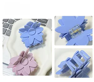 Vue détaillée des pinces à cheveux fleurs lavande et rose poudré avec mécanisme à ressort