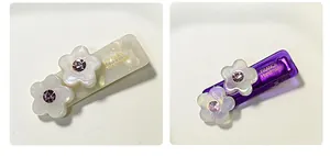 Dettaglio di fermagli per capelli a fiore in acetato con petali lucidi e gemme viola