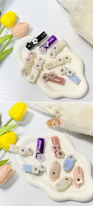 Dettaglio dei fermagli per capelli a fiori in acetato con cristalli scintillanti