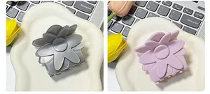 Détail de pinces à cheveux à fleurs en gris et violet clair avec fini nacré élégant