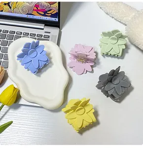 Gros plan de pinces à cheveux fleurs pastel en cinq couleurs sur un bureau décoré