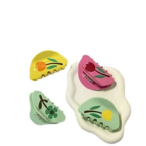 Set di quattro mollette per capelli opache con motivi a tulipano su vassoio bianco
