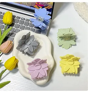 Lot de cinq pinces à cheveux fleurs mates aux couleurs pastel sur un plateau blanc