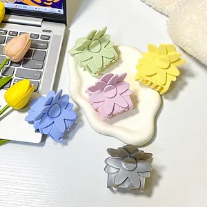 Lot de cinq pinces à cheveux fleur mat pastel sur un bureau avec des tulipes